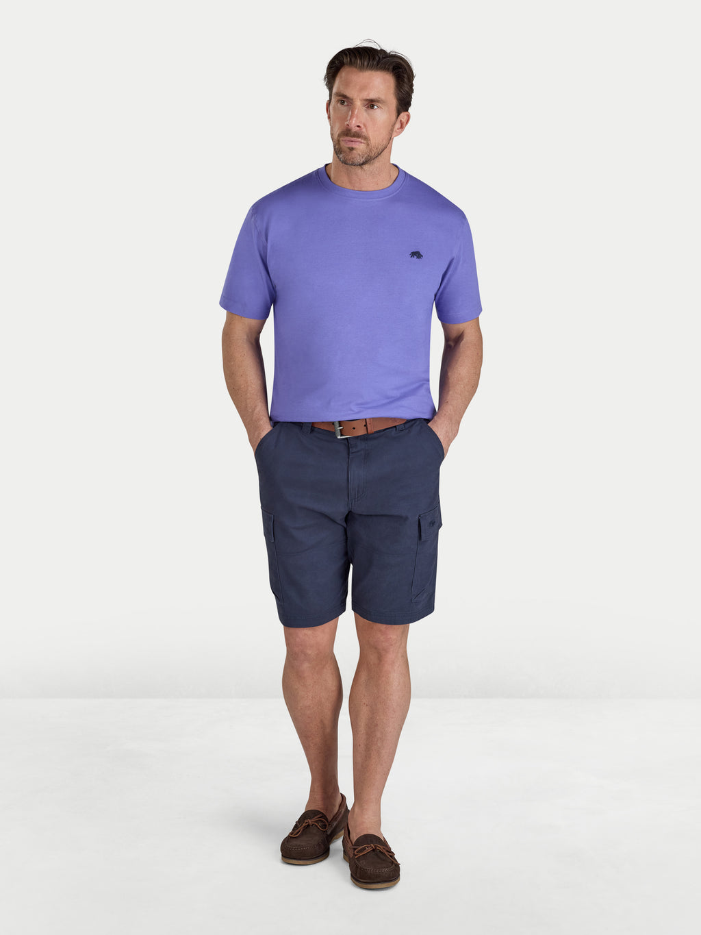 Man wearing a purple t-shirt and navy shorts on a white background