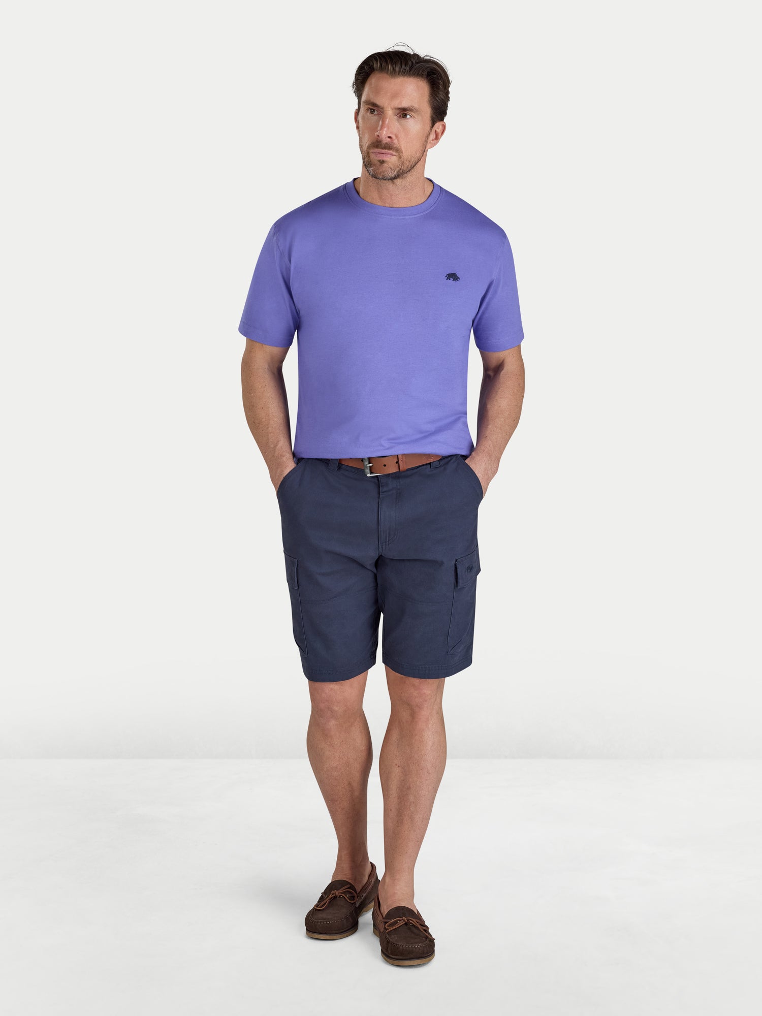 Man wearing a purple t-shirt and navy shorts on a white background