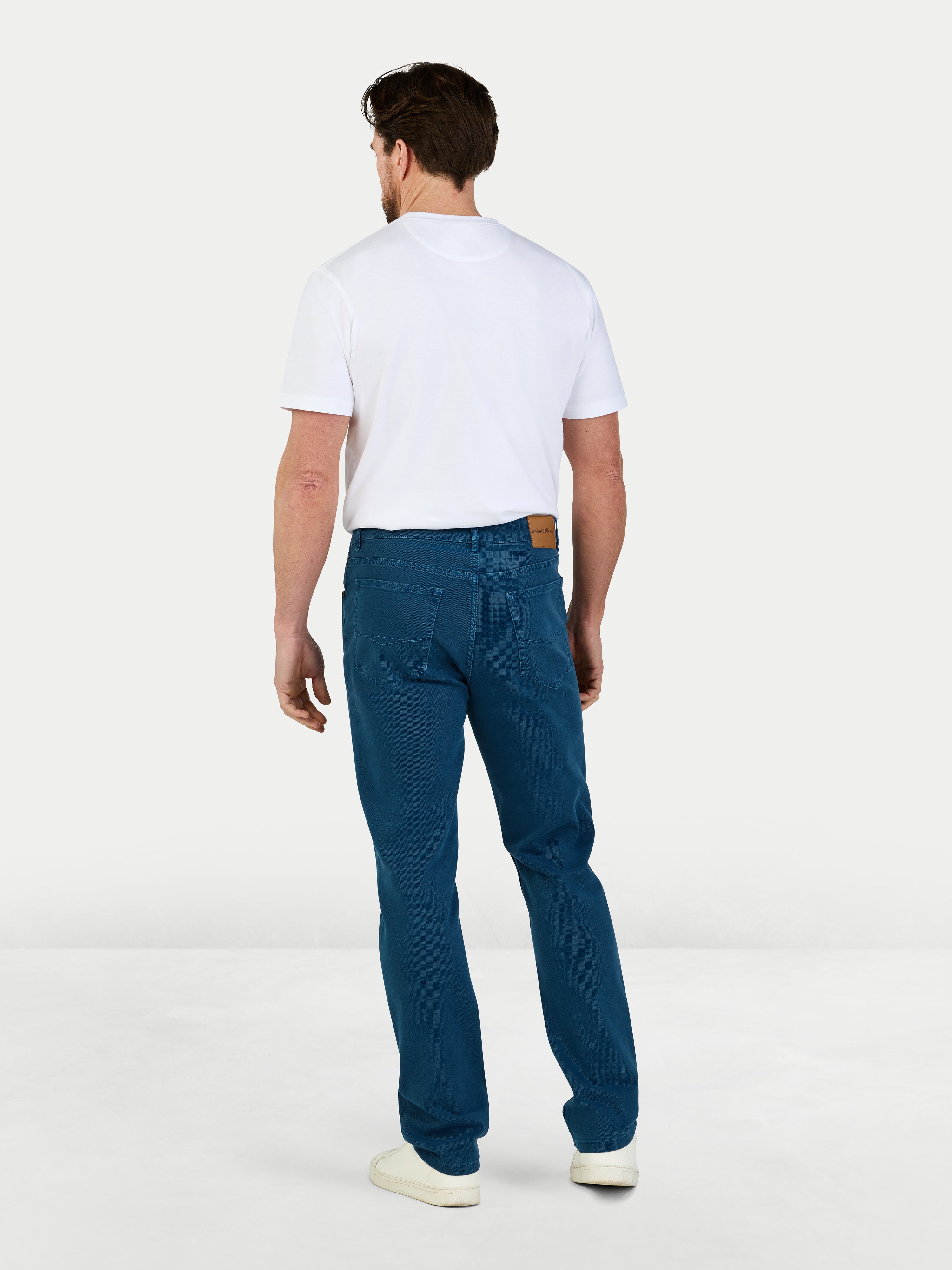 Man wearing a white t-shirt and blue jeans on a white background