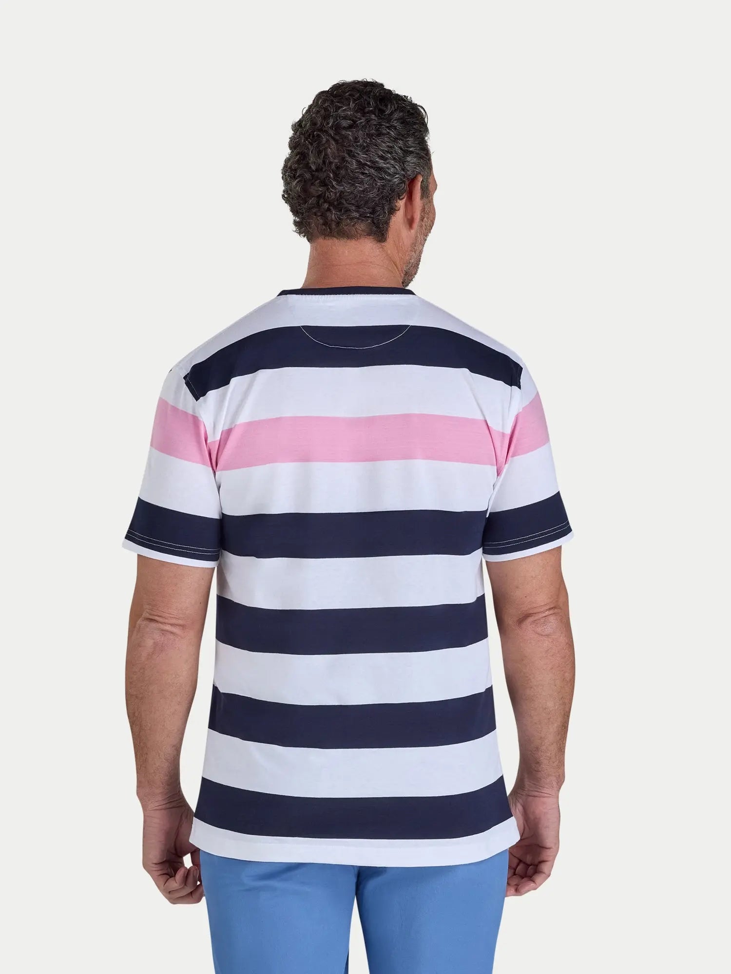 Person wearing a striped shirt with pink, white, and navy blue horizontal stripes on a plain background.