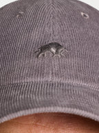 Gray cap with a logo on a person wearing it