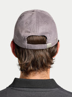 Person wearing a gray cap from behind on a light gray background