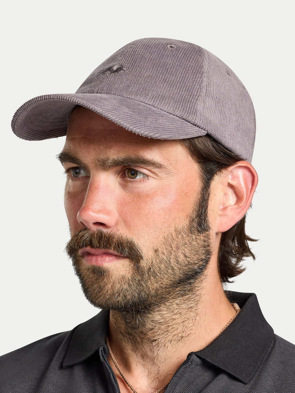 Man wearing a gray baseball cap against a white background
