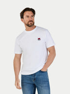 Man wearing a white t-shirt with a small logo on a plain background