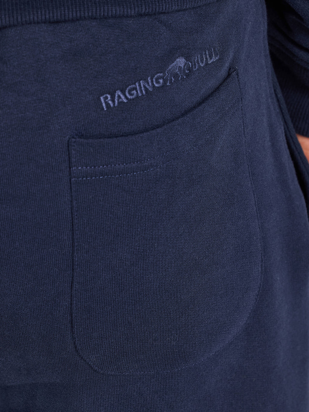Navy blue sweatpants with 'Raging Bull' logo on pocket