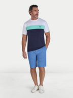 Man wearing a color-blocked t-shirt and blue shorts on a white background