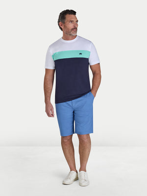 Man wearing a color-blocked t-shirt and blue shorts on a white background