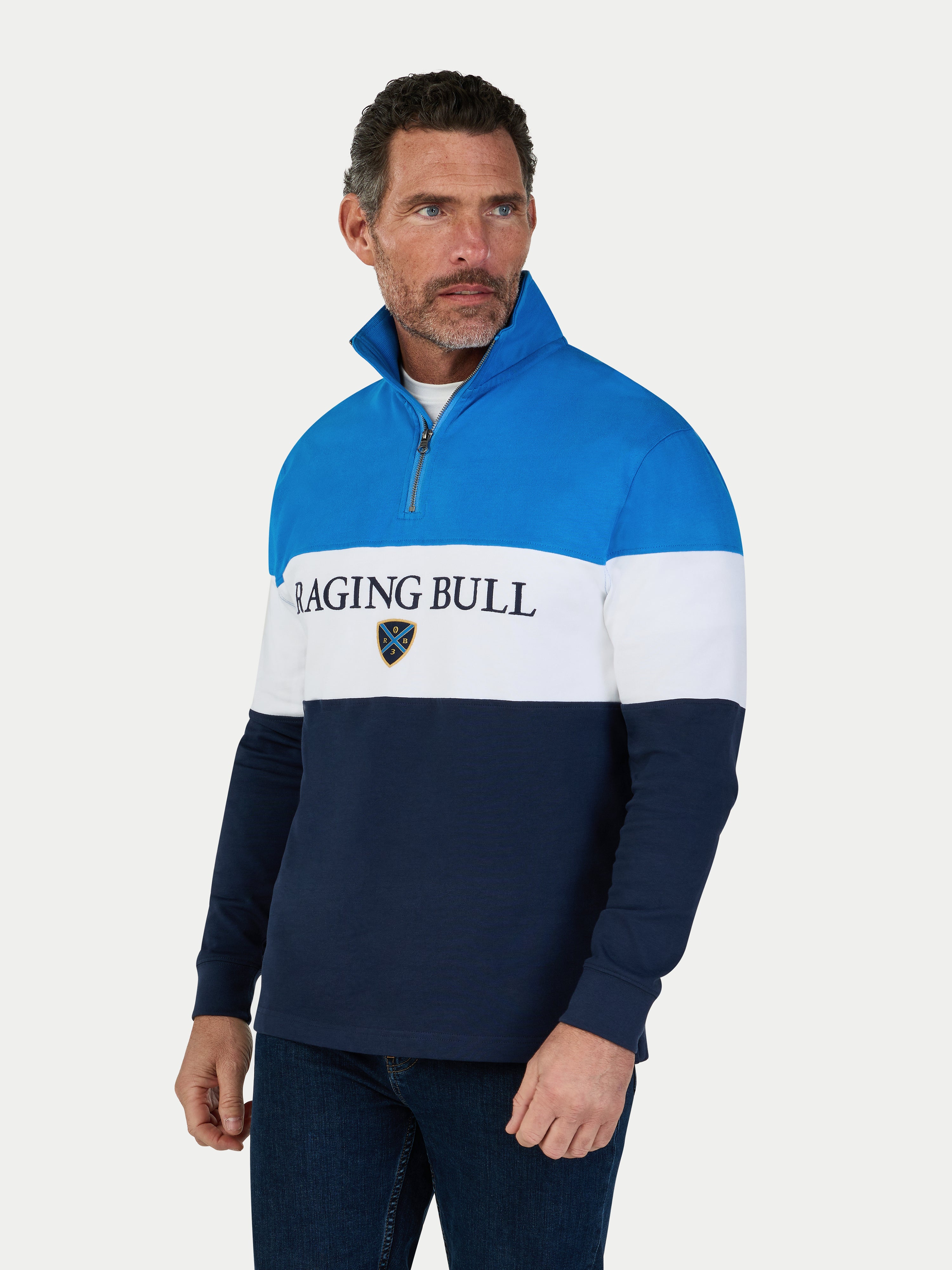 Man wearing a blue and white pullover with 'Raging Bull' branding on a white background