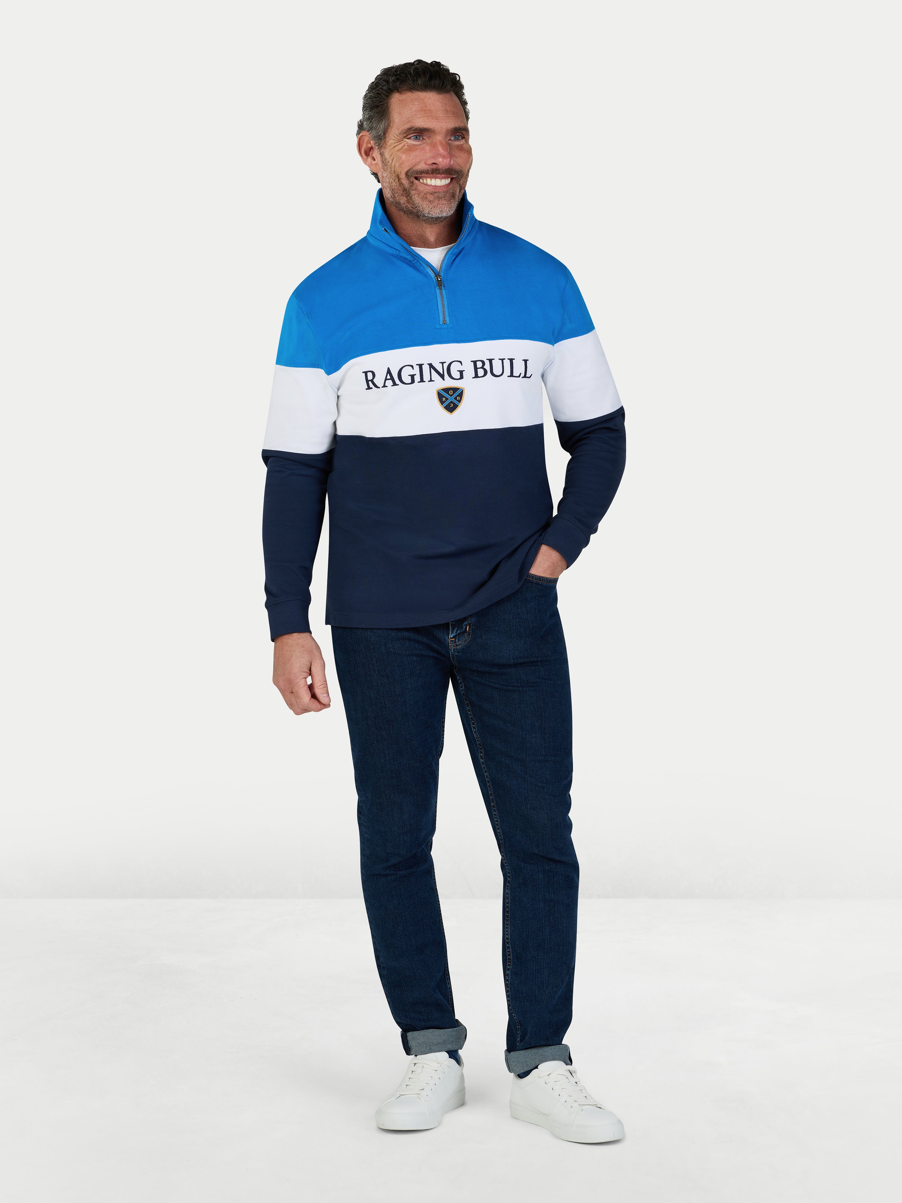 Man wearing a blue and white striped sweater with 'Raging Bull' logo on a white background