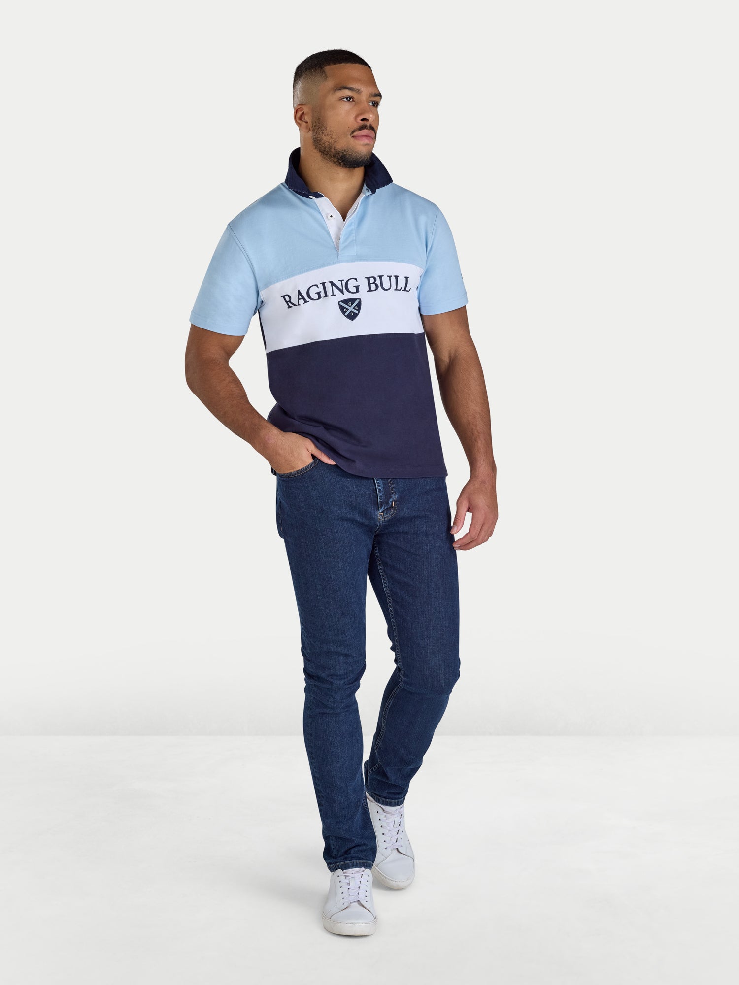Man wearing a blue and white polo shirt with 'Raging Bull' branding on a white background