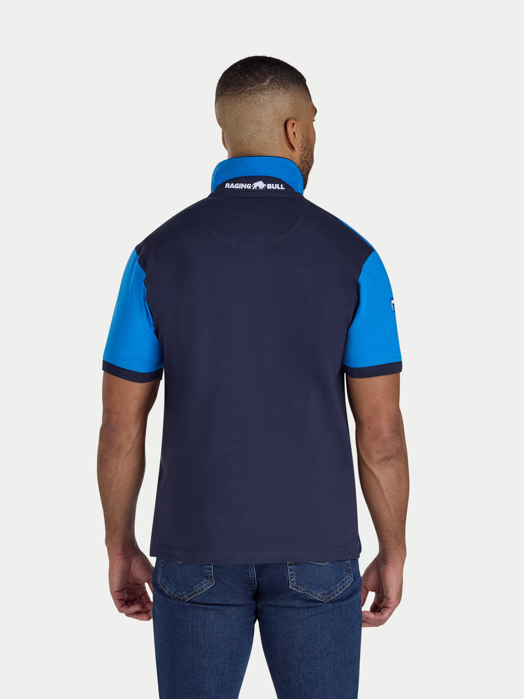 Man wearing a navy and blue polo shirt with a visible brand logo on the back.