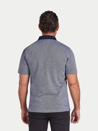 Man wearing a patterned polo shirt on a light gray background
