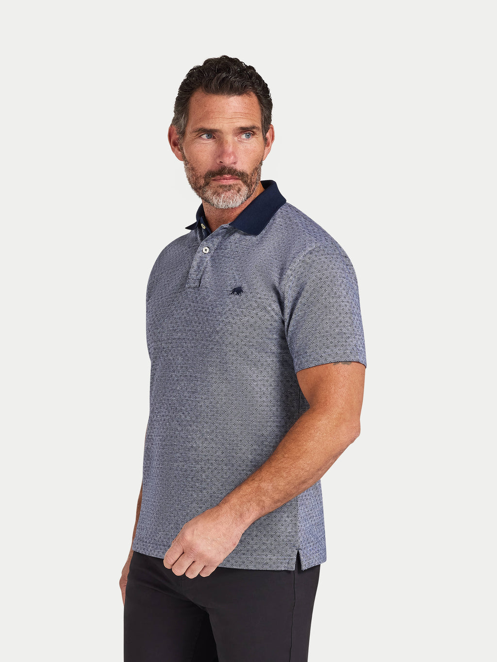 Man wearing a patterned polo shirt with a white background