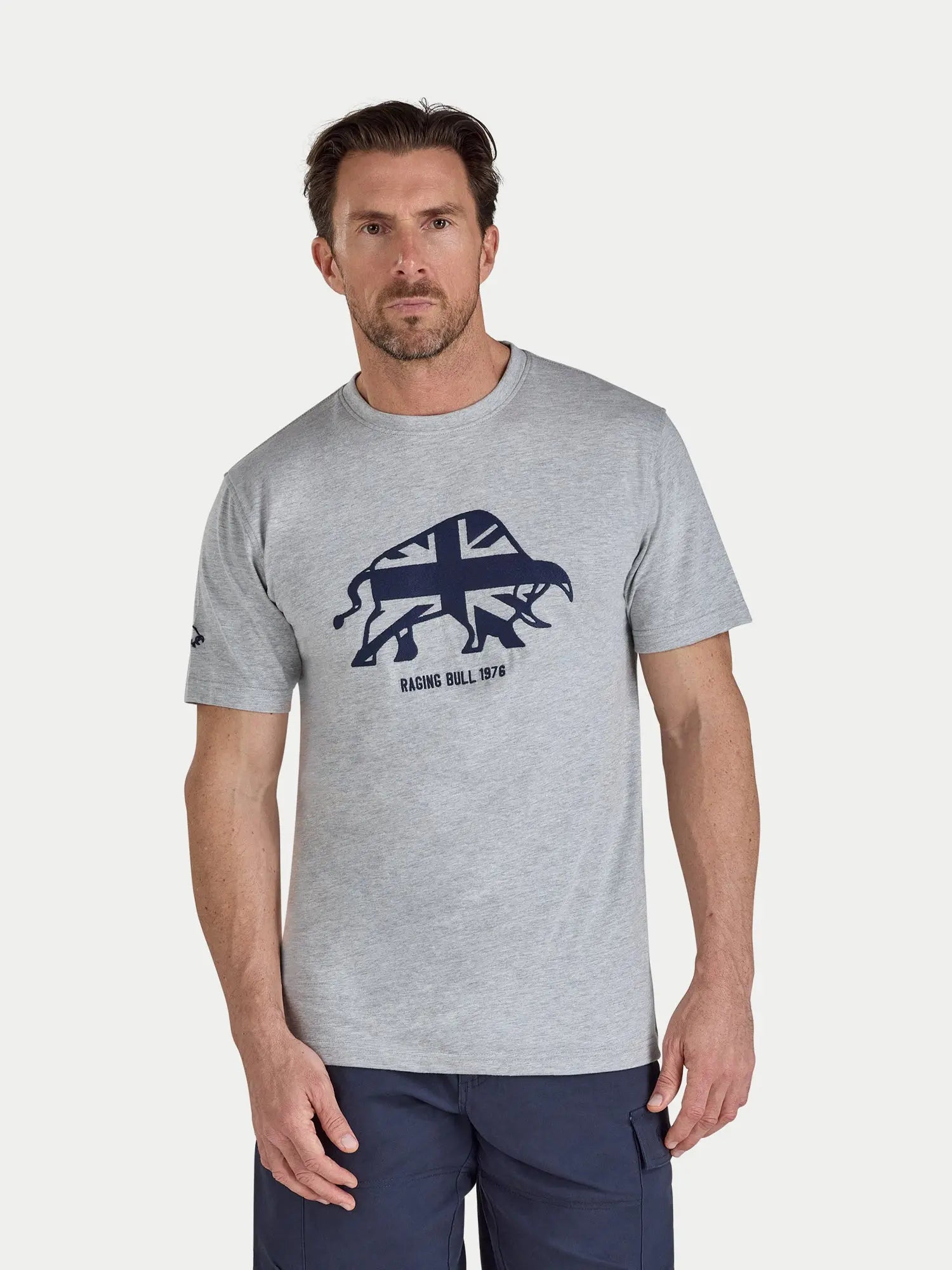 Man wearing a gray t-shirt with a graphic design on a white background