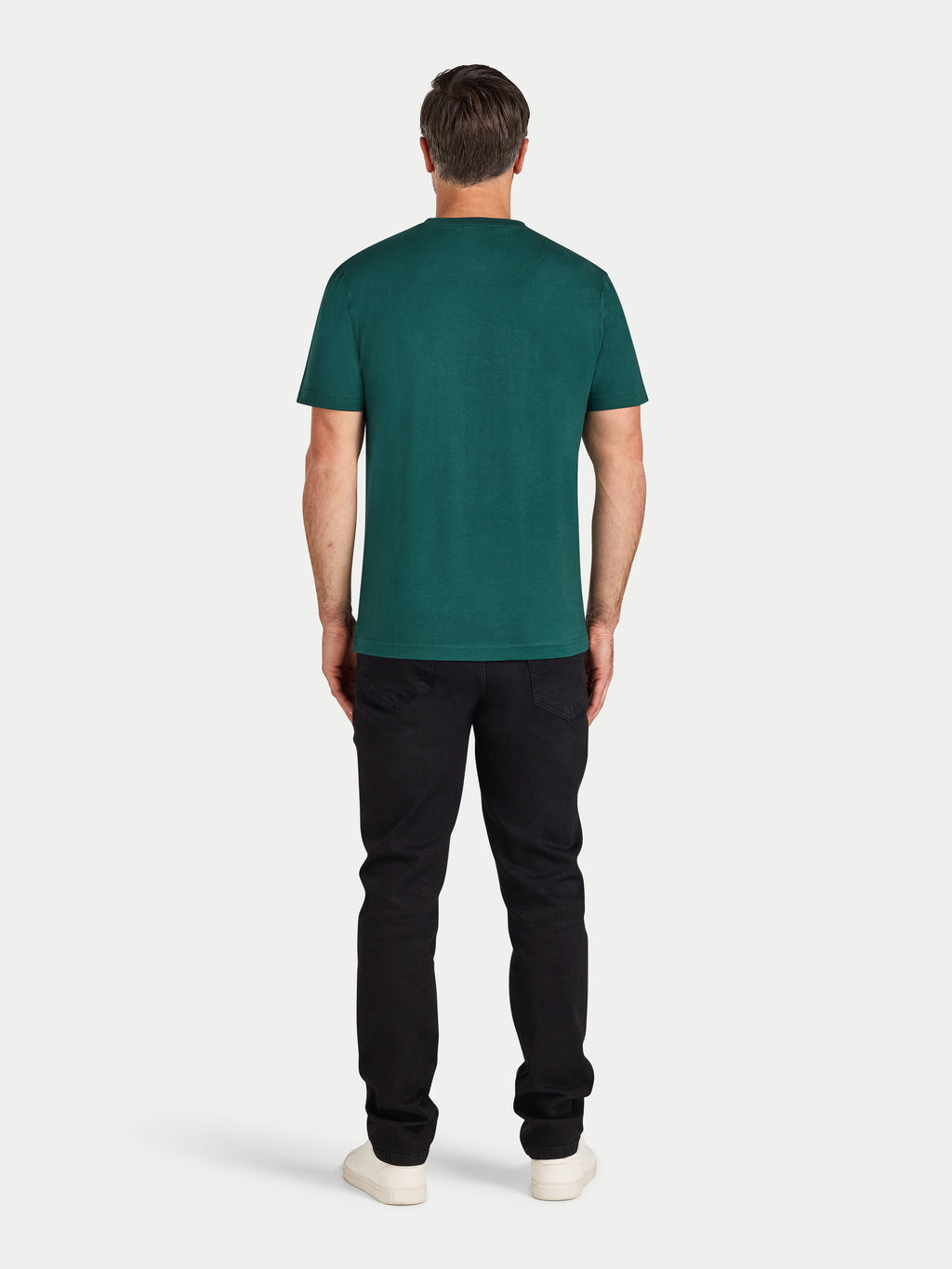 Man wearing a green t-shirt and black pants on a white background