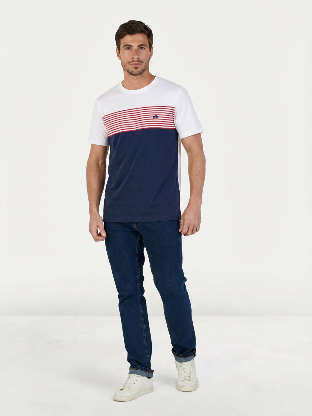 Man wearing aRaging Bull Engineered stripe t-shirt in navy, white and red and Regular jeans in denim, front. 