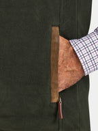 Close-up of a greengilet with brown leather zipper, worn by a person with a checkered shirt sleeve.