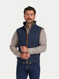Man wearing a navy blue fleece vest over a plaid shirt on a white background