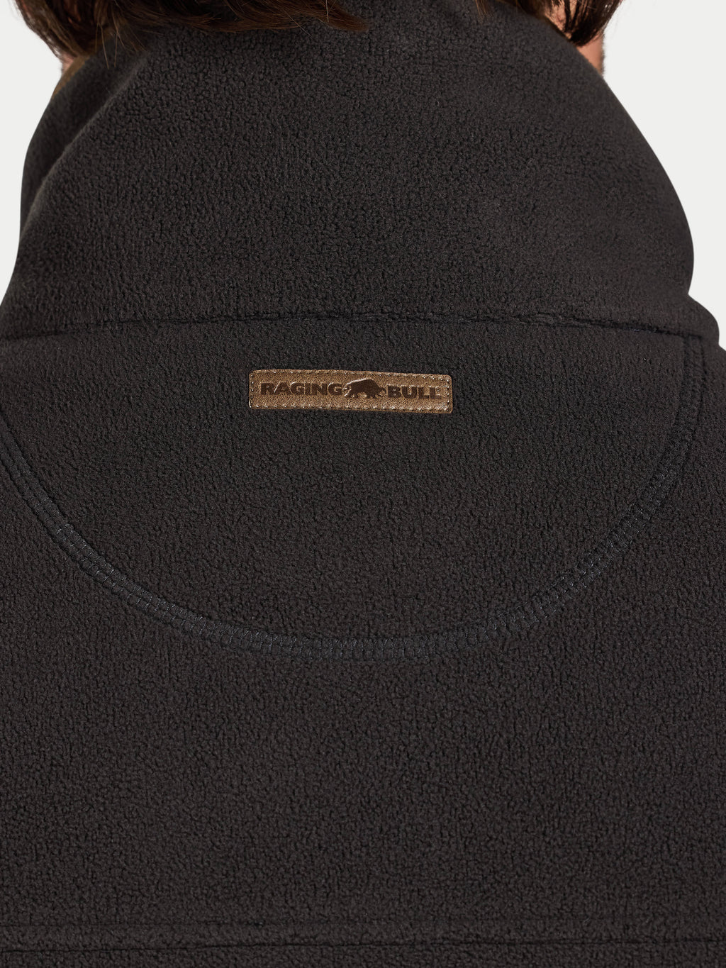Close-up of a slate coloured fleece gilet with a brand logo on the chest.