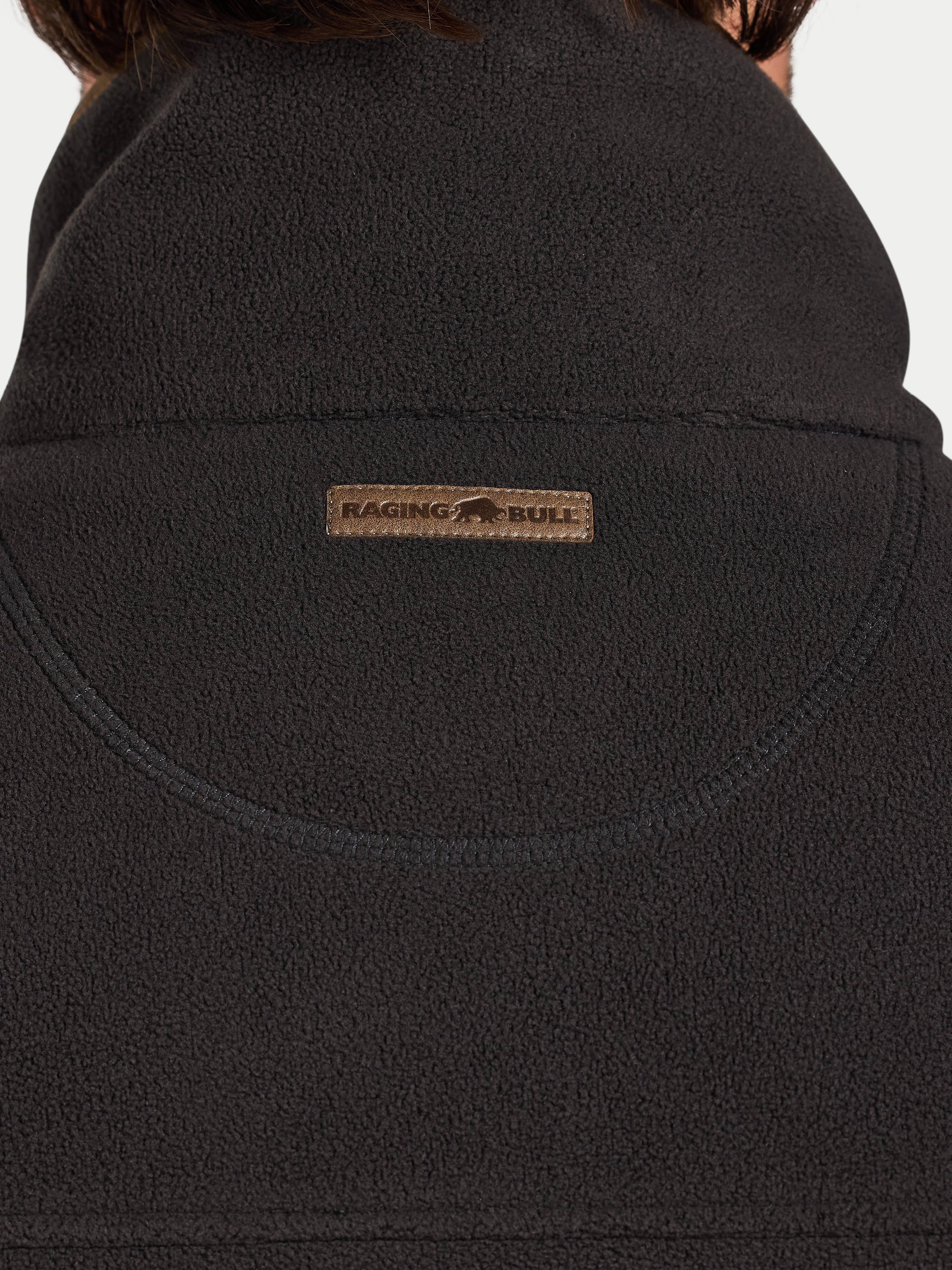 Close-up of a slate coloured fleece gilet with a brand logo on the chest.