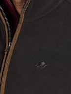 Close-up of a dark jacket with a zipper and Raging Bull logo.