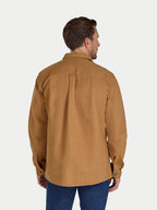 Man wearing a brown shirt and blue jeans on a white background