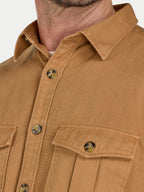 Close-up of a brown shirt with buttons and a collar on a plain background