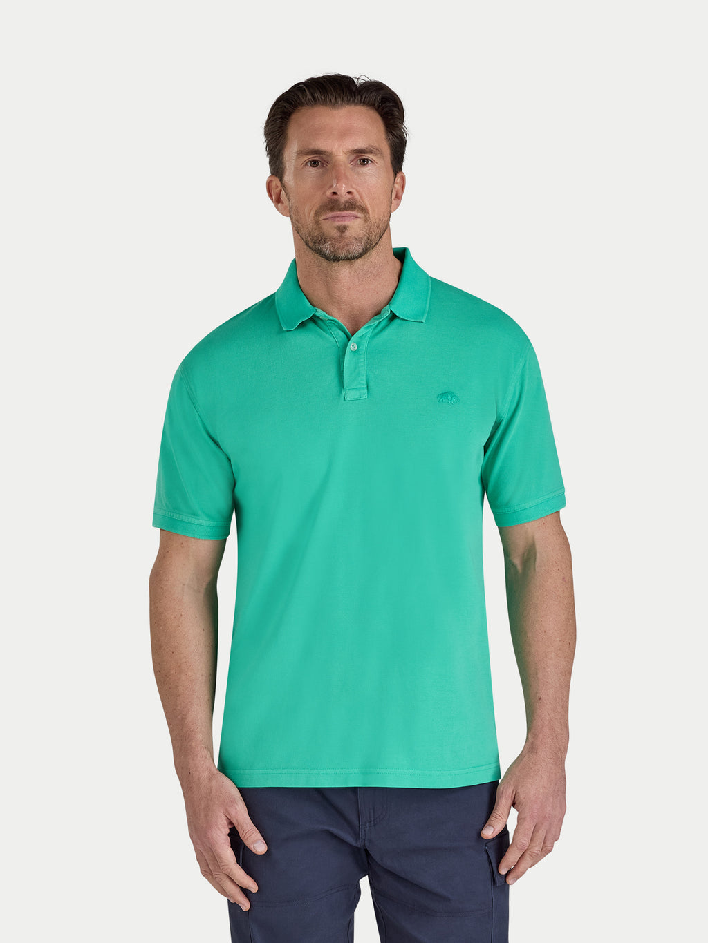 Man wearing a green polo shirt on a light gray background
