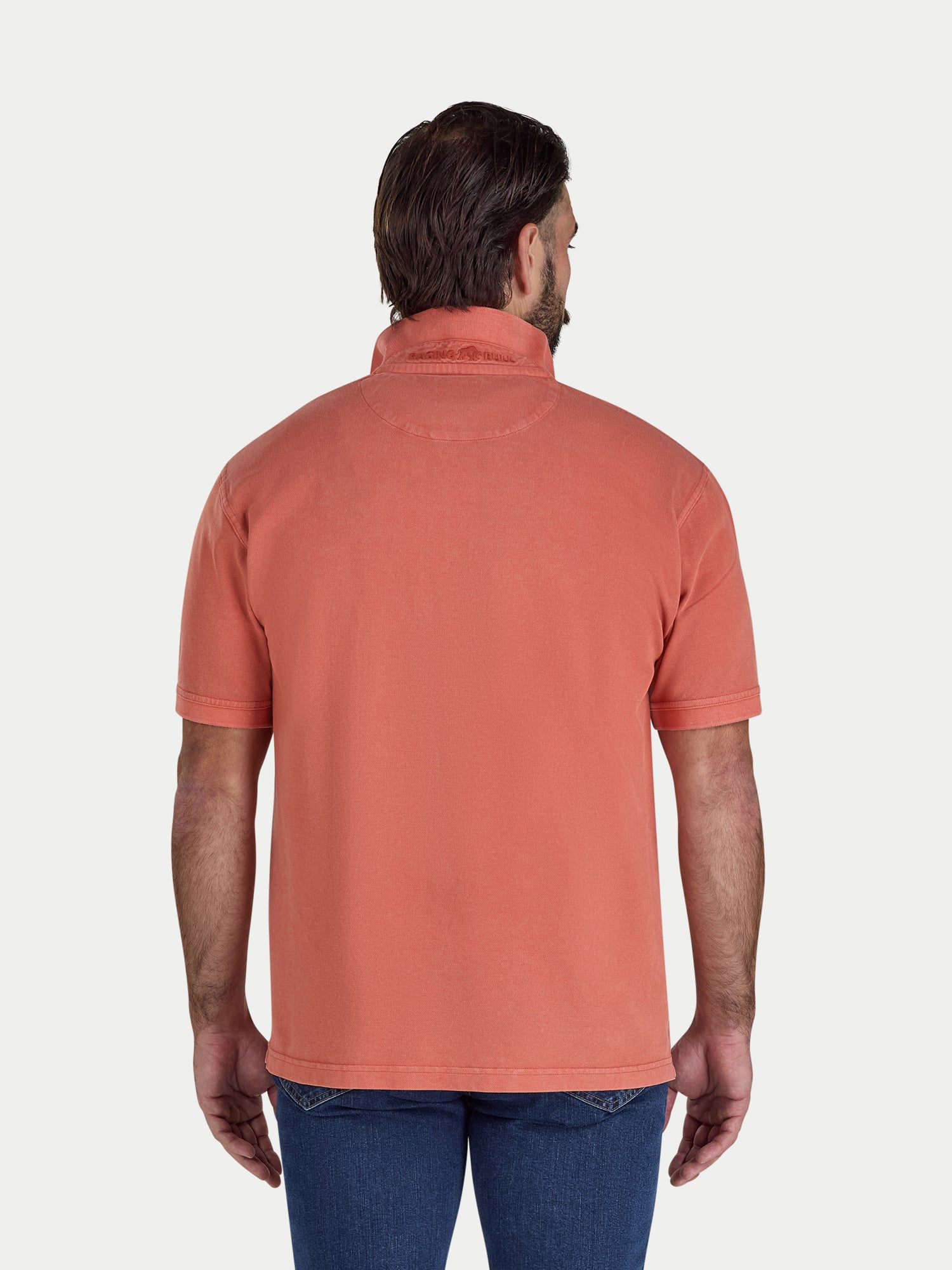 Man wearing an orange polo shirt on a white background