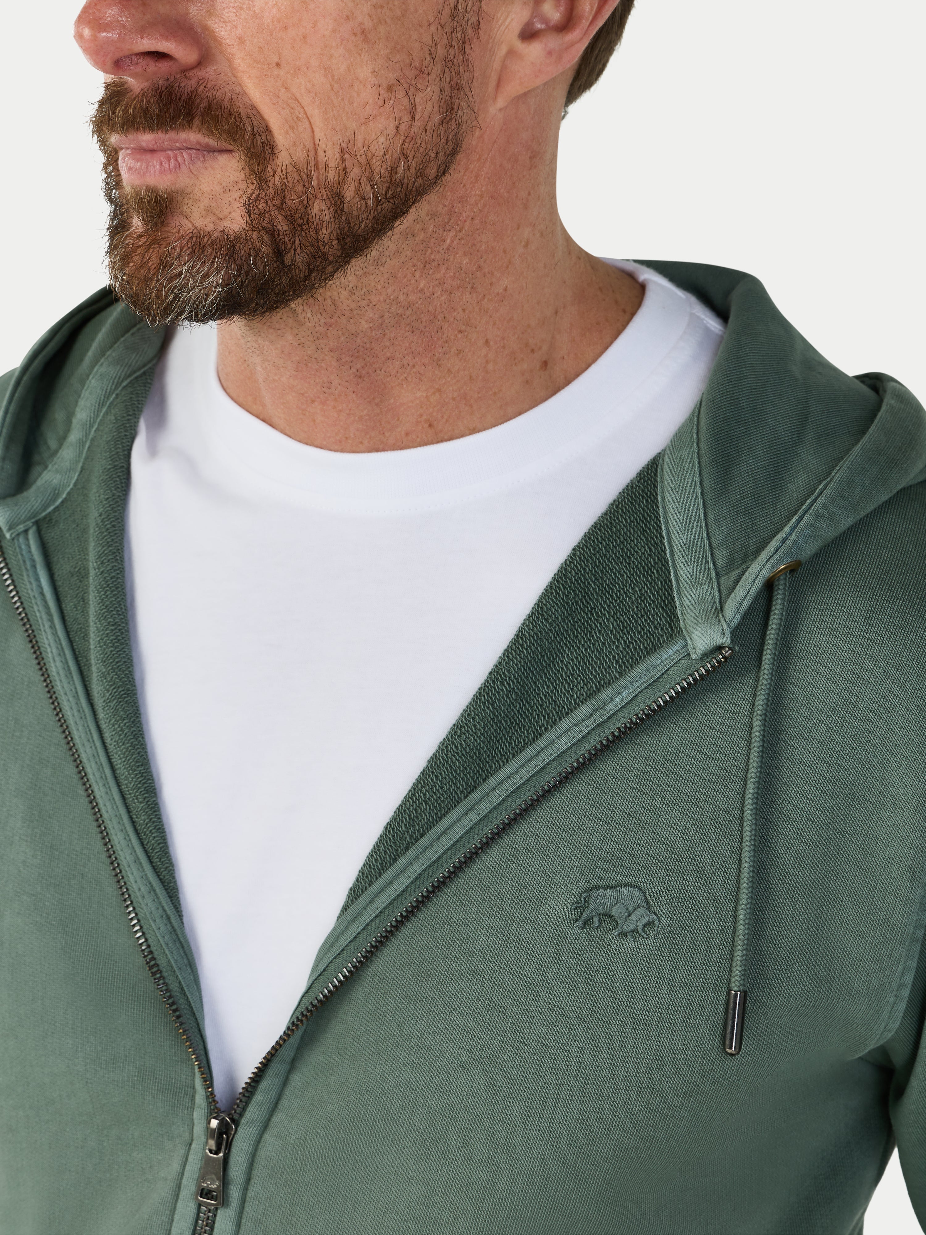Man wearing a green hoodie with a logo on a white background