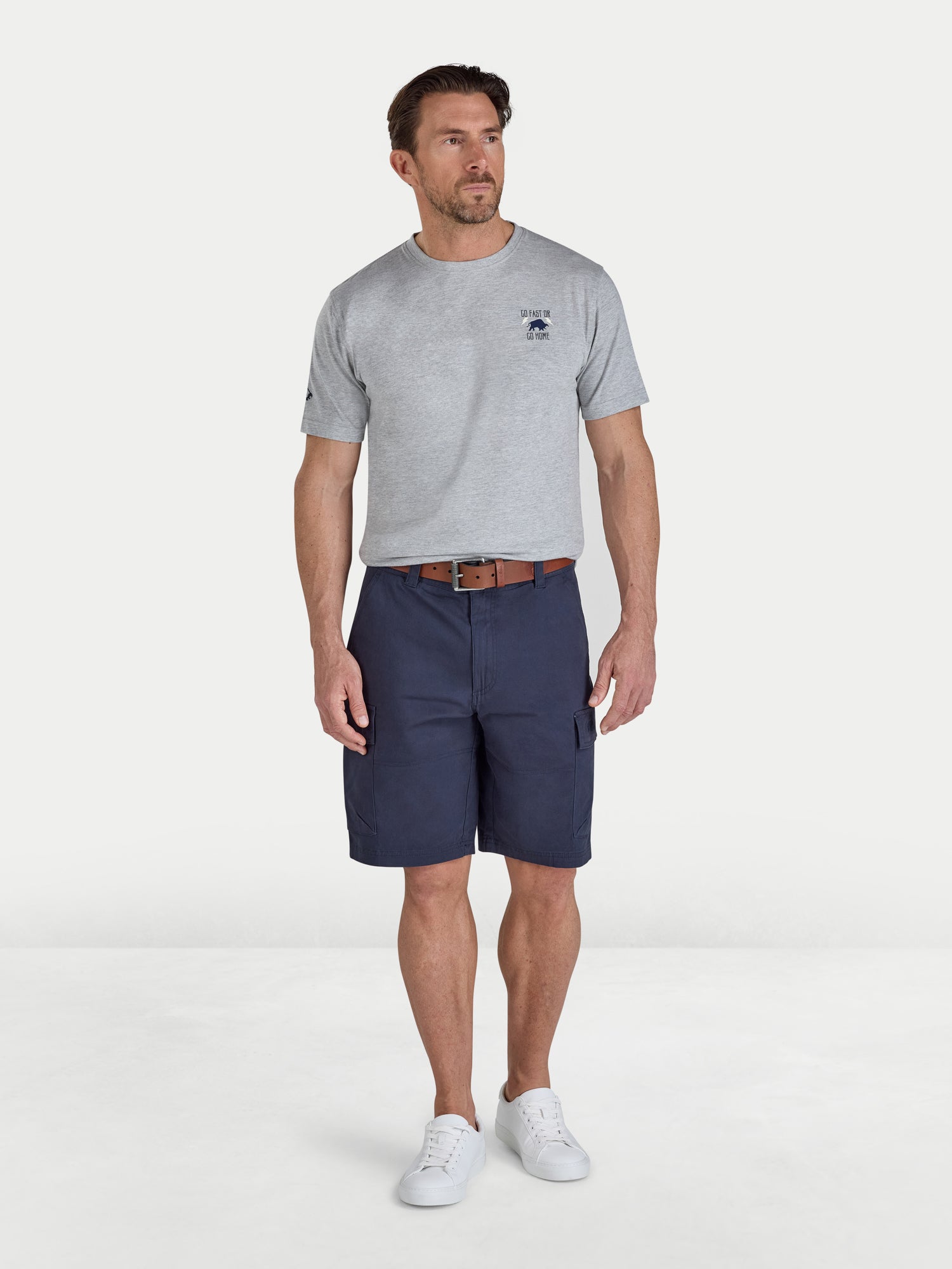 Man wearing a gray t-shirt and navy shorts on a white background