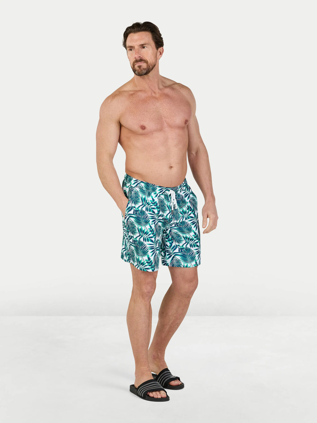 Man wearing Raging Bull Hawaiian Patterned Swim Shorts - Green, front. 