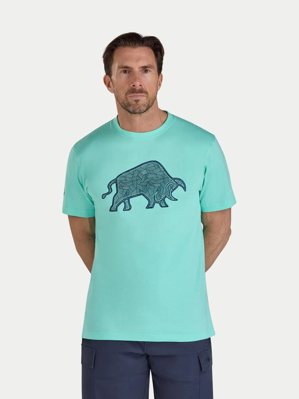 Man wearing a mint green t-shirt with a graphic design on a white background