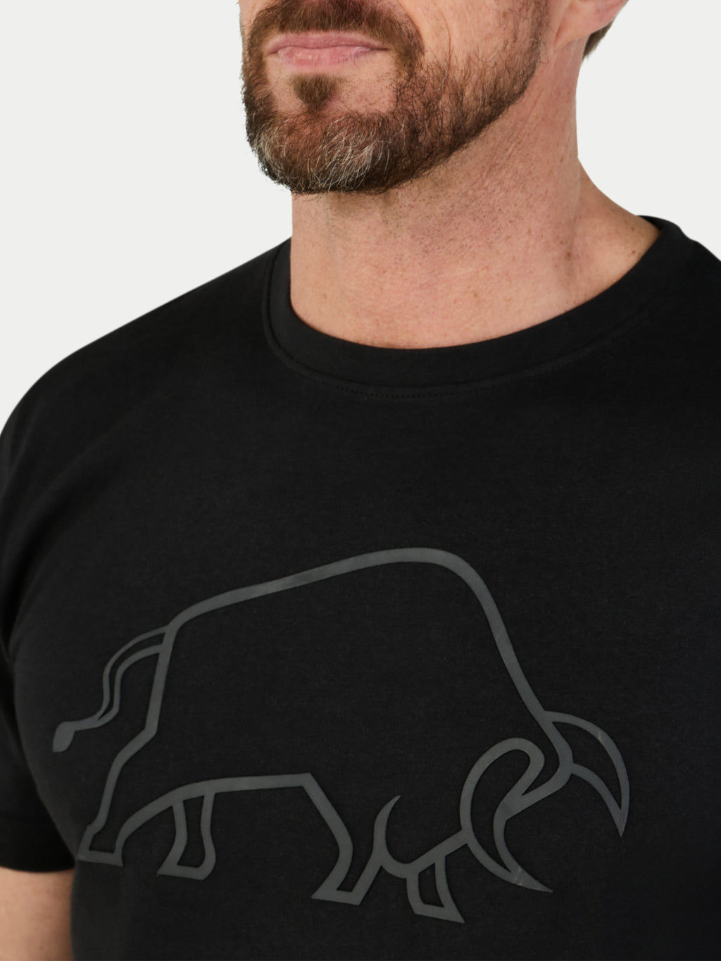 Man wearing a black t-shirt with a bull logo on a white background