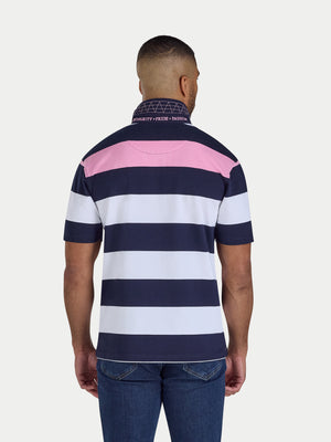 Man wearing a navy, pink, and white striped polo shirt on a light gray background