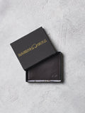 Brown leather wallet with 'Raging Bull' branding on a gray surface