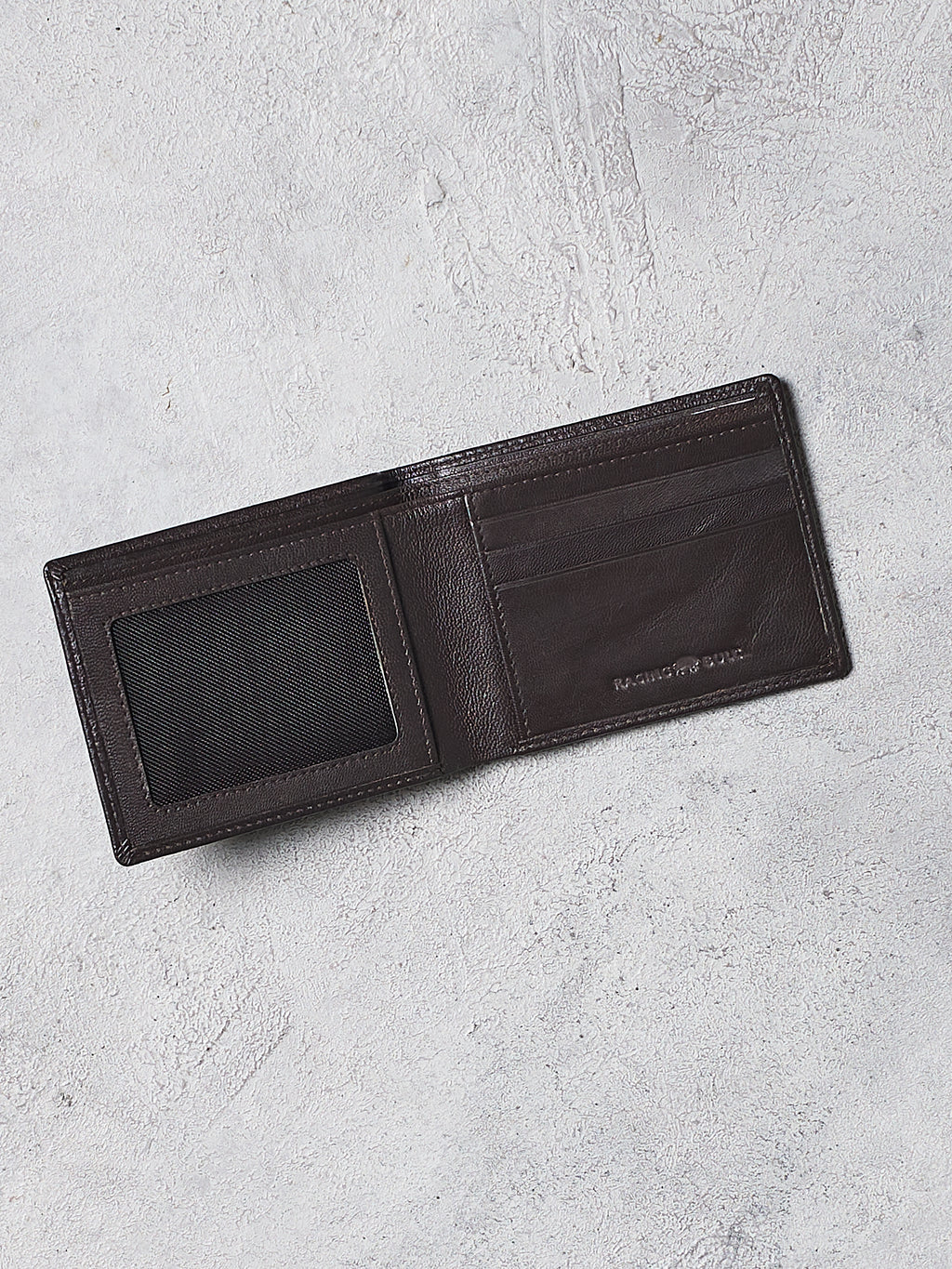 Black leather wallet on a light gray textured surface