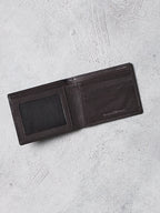 Black leather wallet on a light gray textured surface