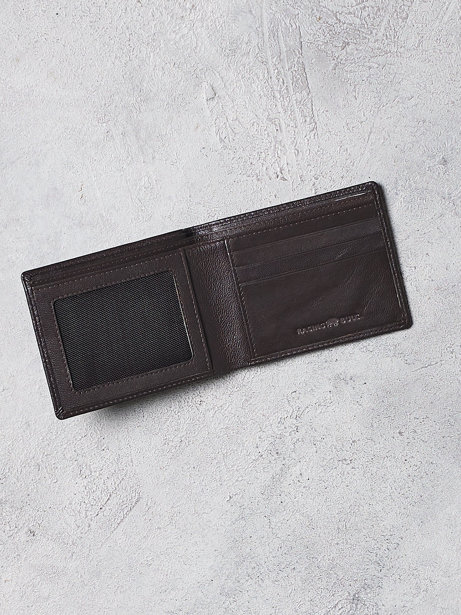 Black leather wallet on a light gray textured surface