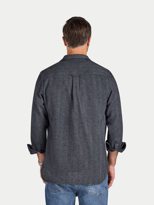 Man wearing a dark denim shirt on a white background