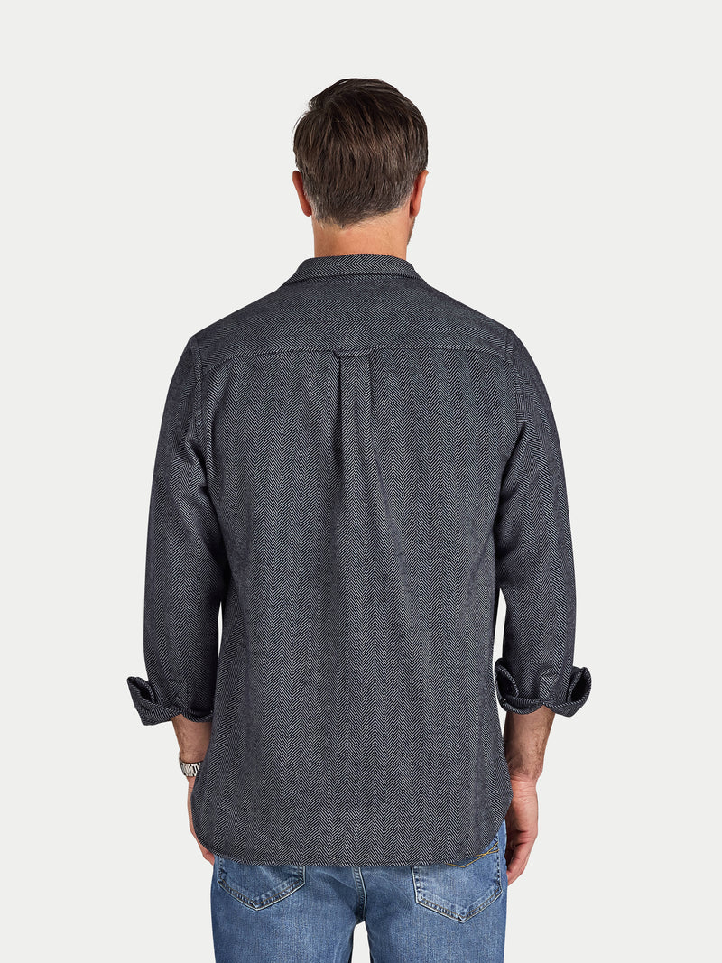 Man wearing a dark denim shirt on a white background