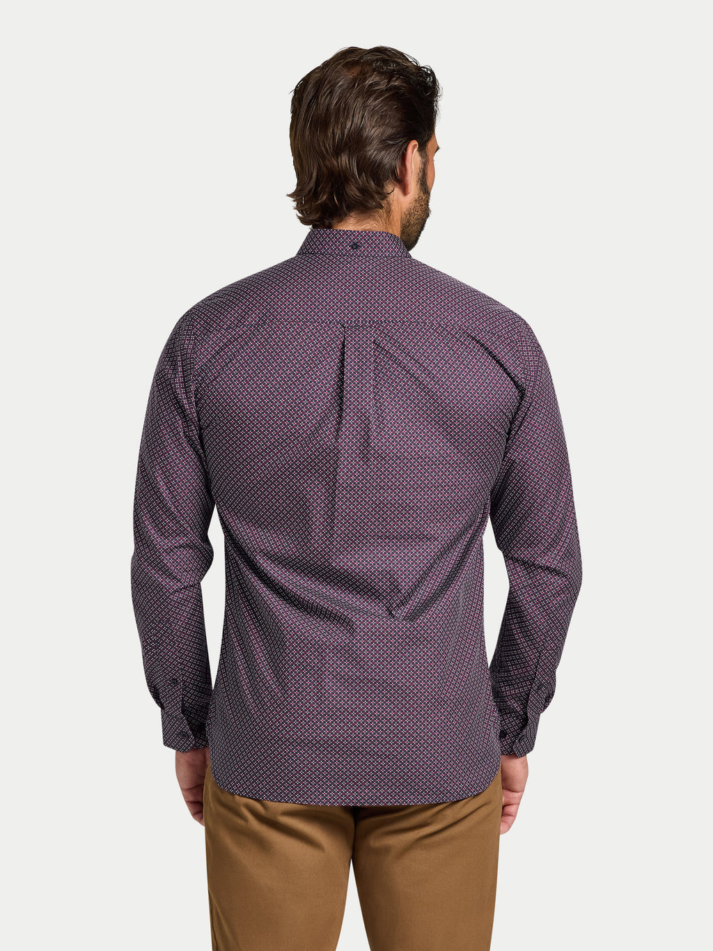 Man wearing a purple patterned shirt on a white background