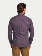 Man wearing a purple patterned shirt on a white background