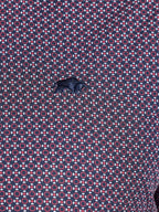 Patterned fabric with geometric design in red and blue on a purple background