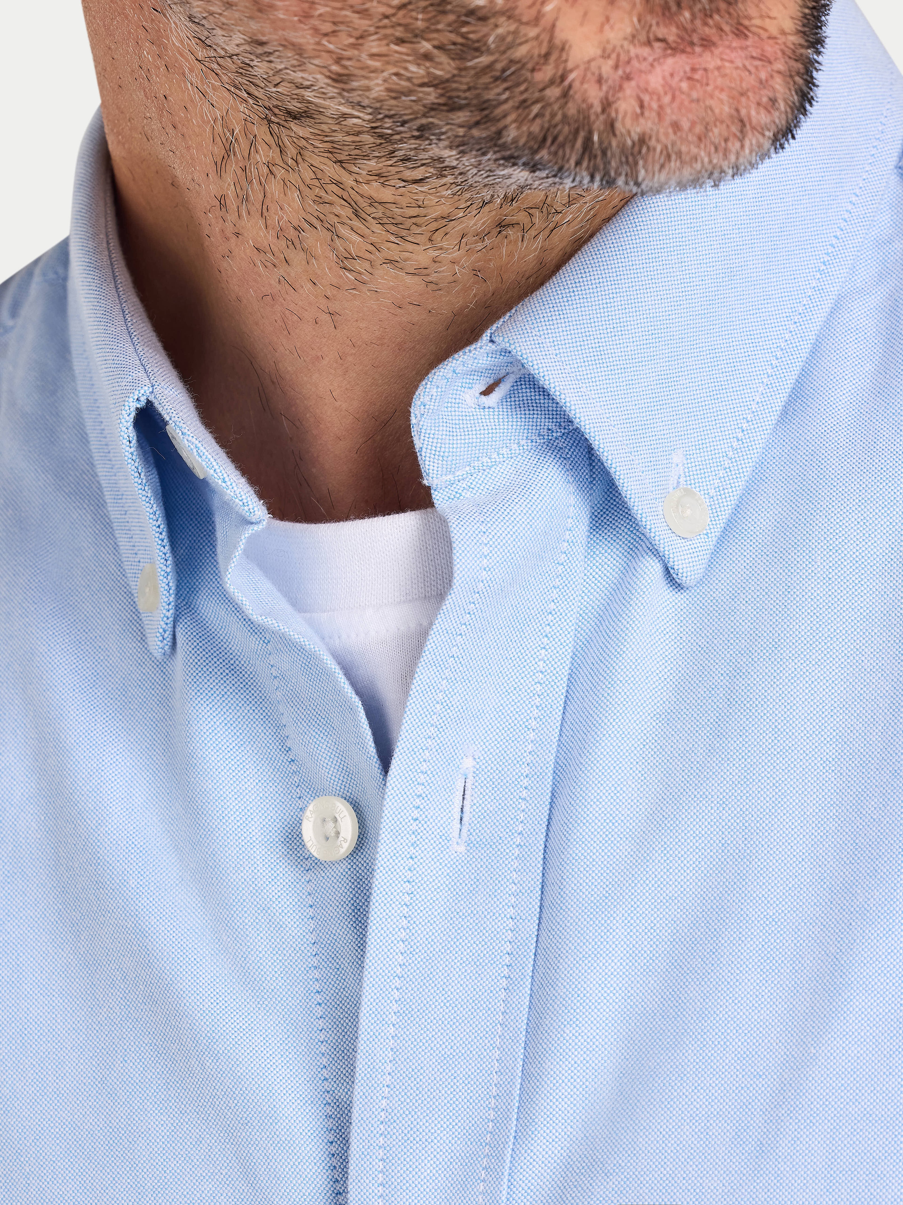 Close-up of a light blue shirt with a collar and buttons.