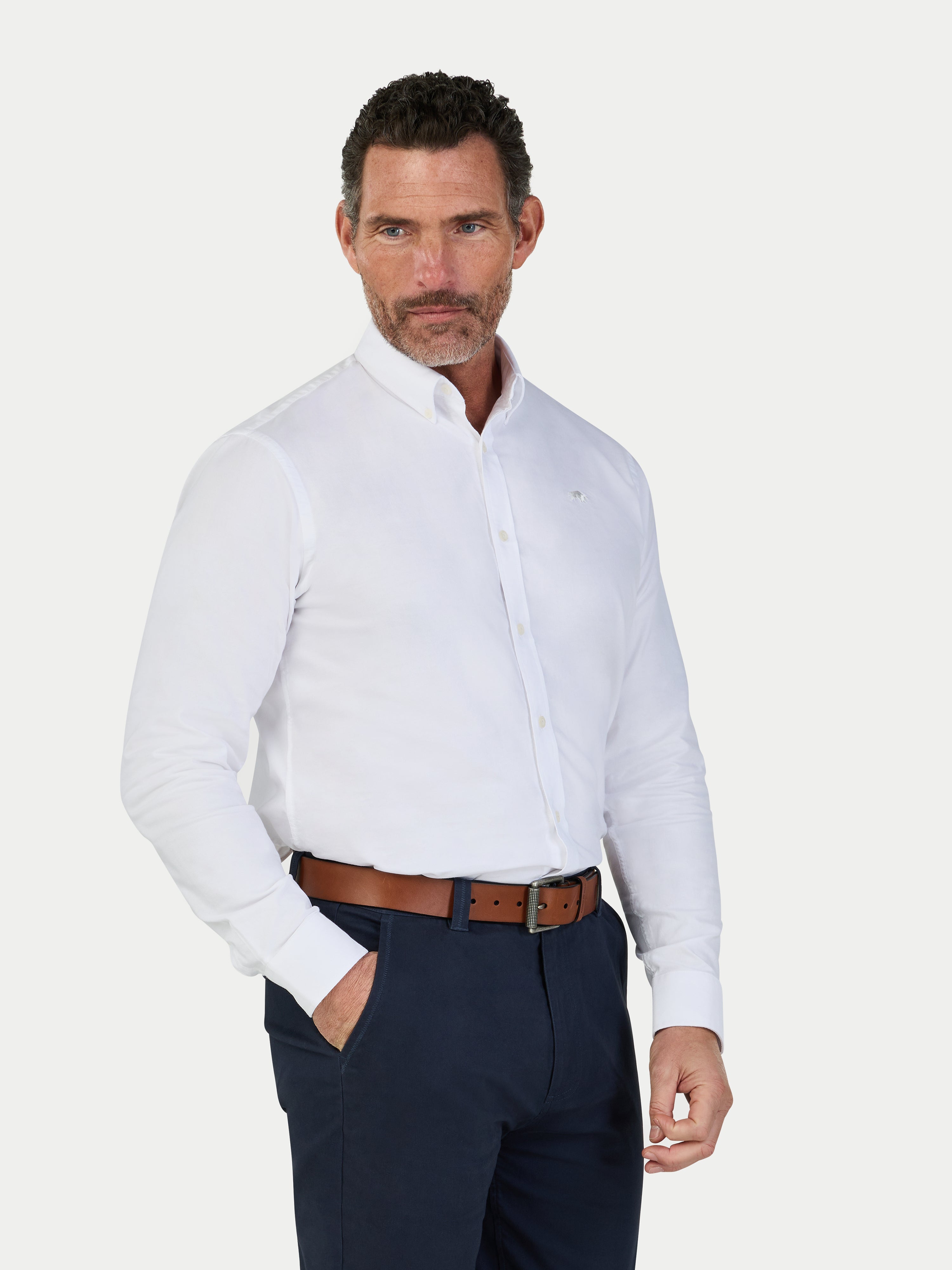 Man wearing a white dress shirt and navy pants on a white background