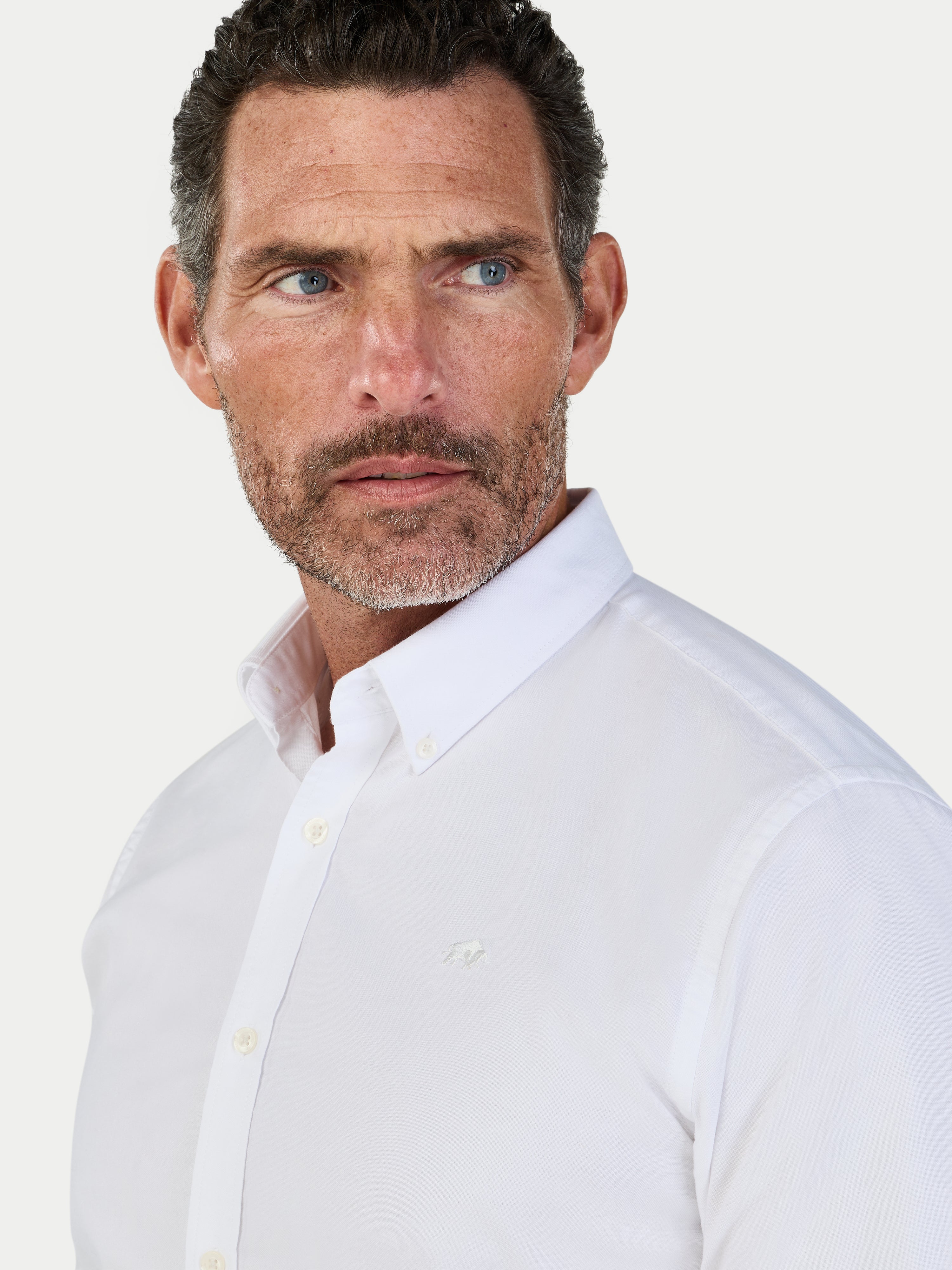 Man wearing a white dress shirt against a light gray background