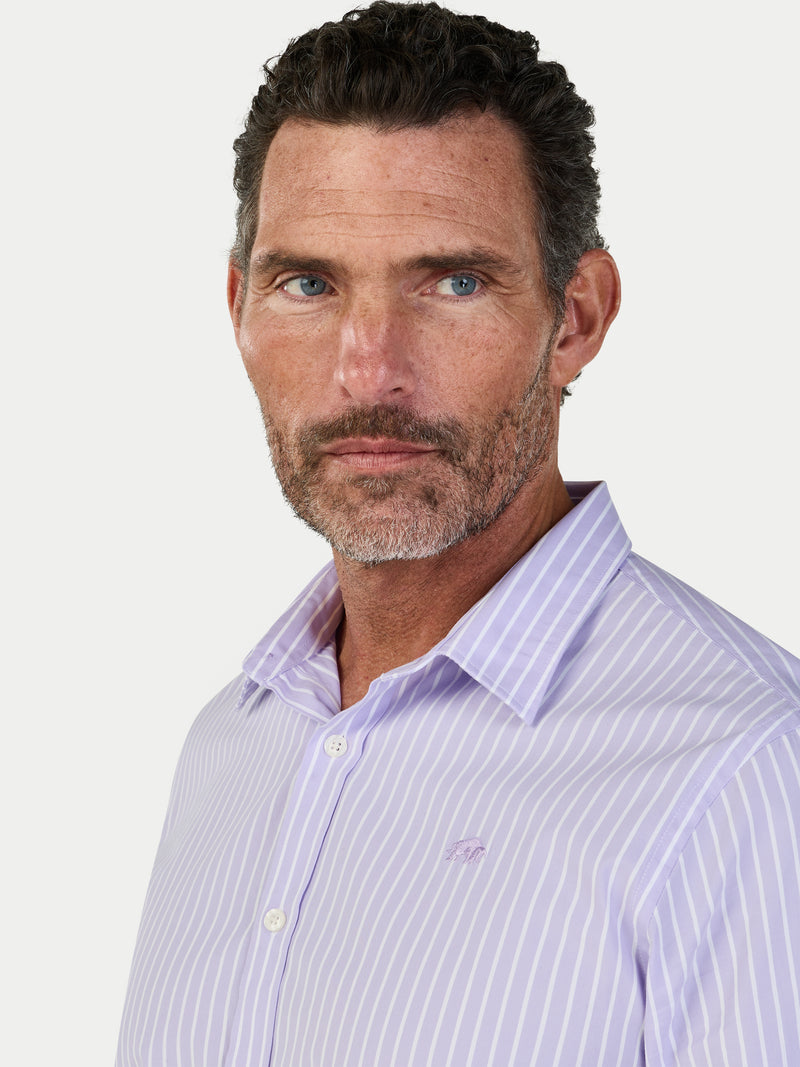 Man wearing a light purple striped shirt against a white background