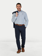 Man wearing a patterned shirt, navy pants, and brown shoes on a white background