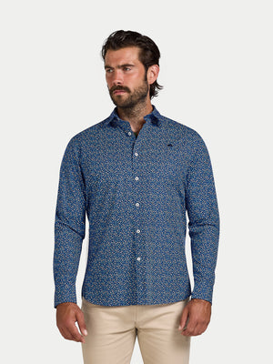 Man wearing a blue patterned shirt and beige pants on a white background